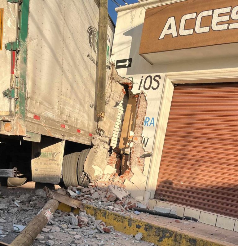 Tráiler impacta de reversa contra negocio y derriba un poste, en Uruapan